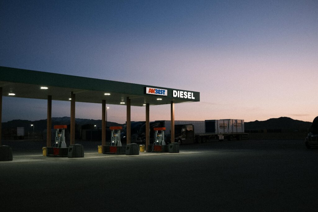 Serene rural gas station scene at twilight, featuring empty pumps and a dramatic sky.