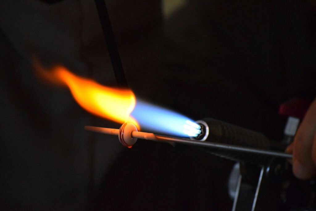 Close-up of a torch flame used in glassblowing, showcasing heat and craftsmanship.