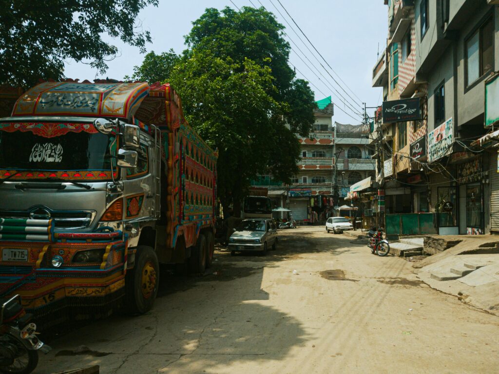 Vibrant decorated truck parked on a bustling Rawalpindi street. Captured with dynamic urban scenery.