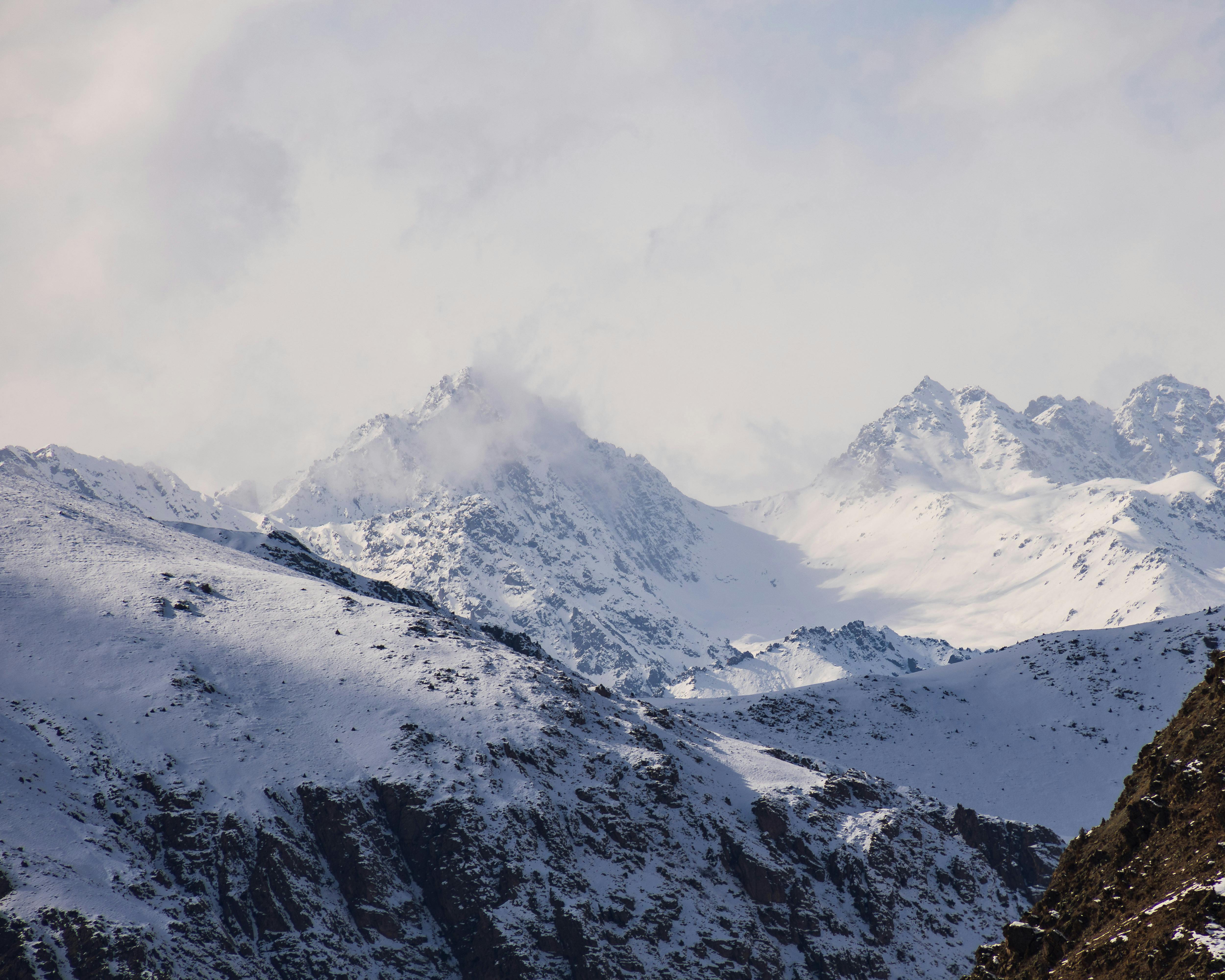 Stunning snowy mountain peaks under cloudy sky, perfect for winter or adventure themes.
