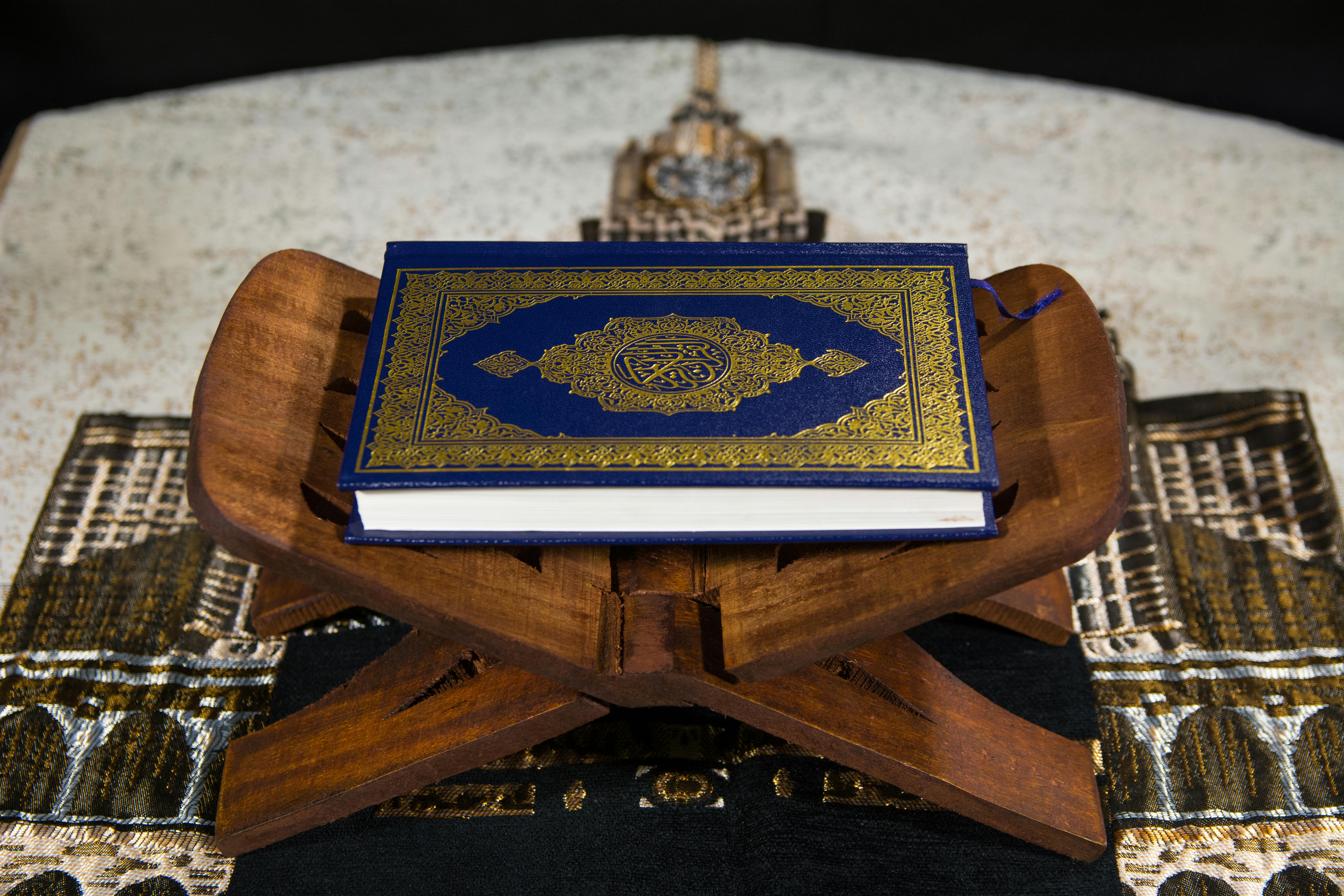 Close-up of the Quran on a wooden stand, symbolizing Islamic spirituality.