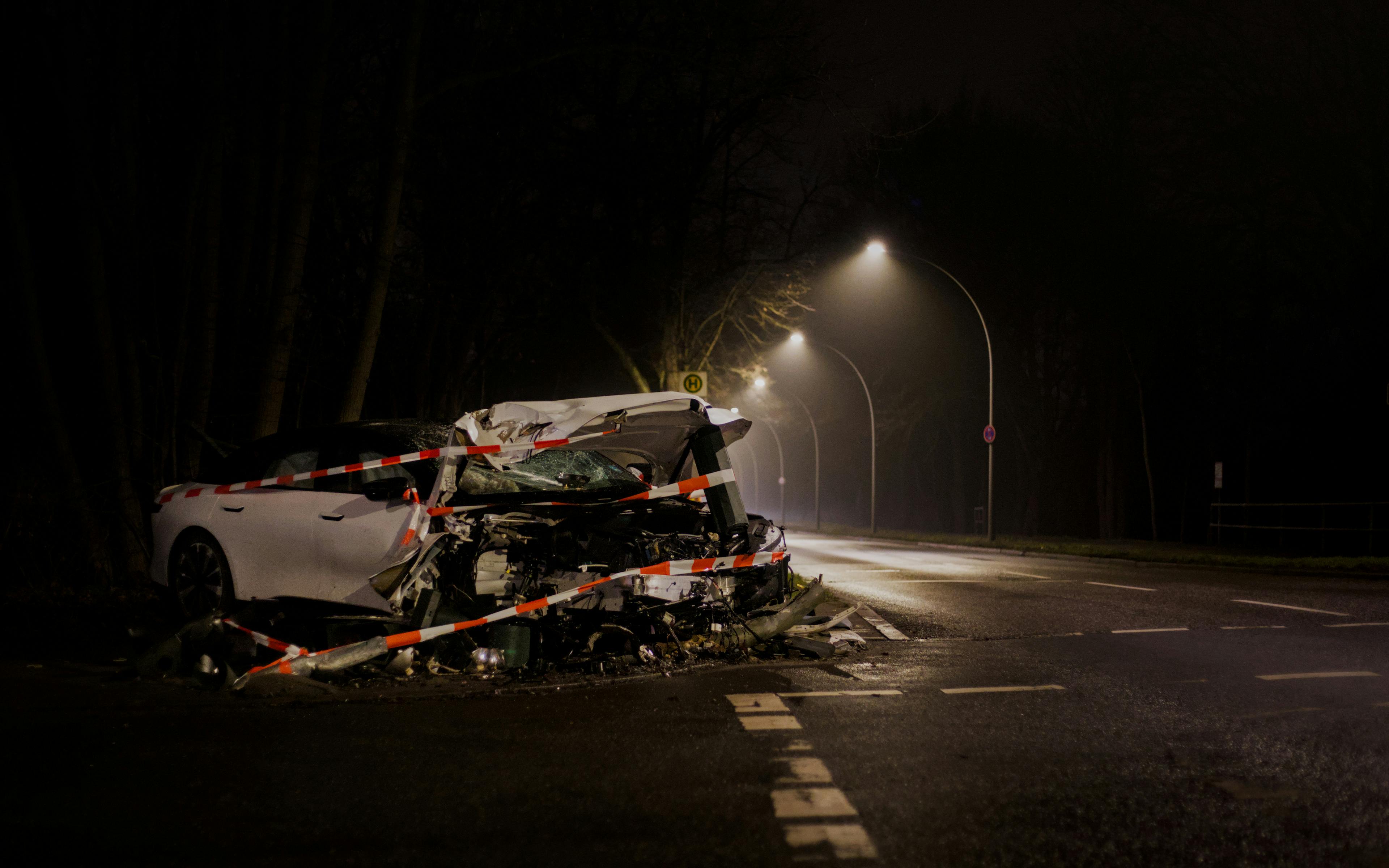 A wrecked car after a crash on a dimly lit street in Berlin at night.