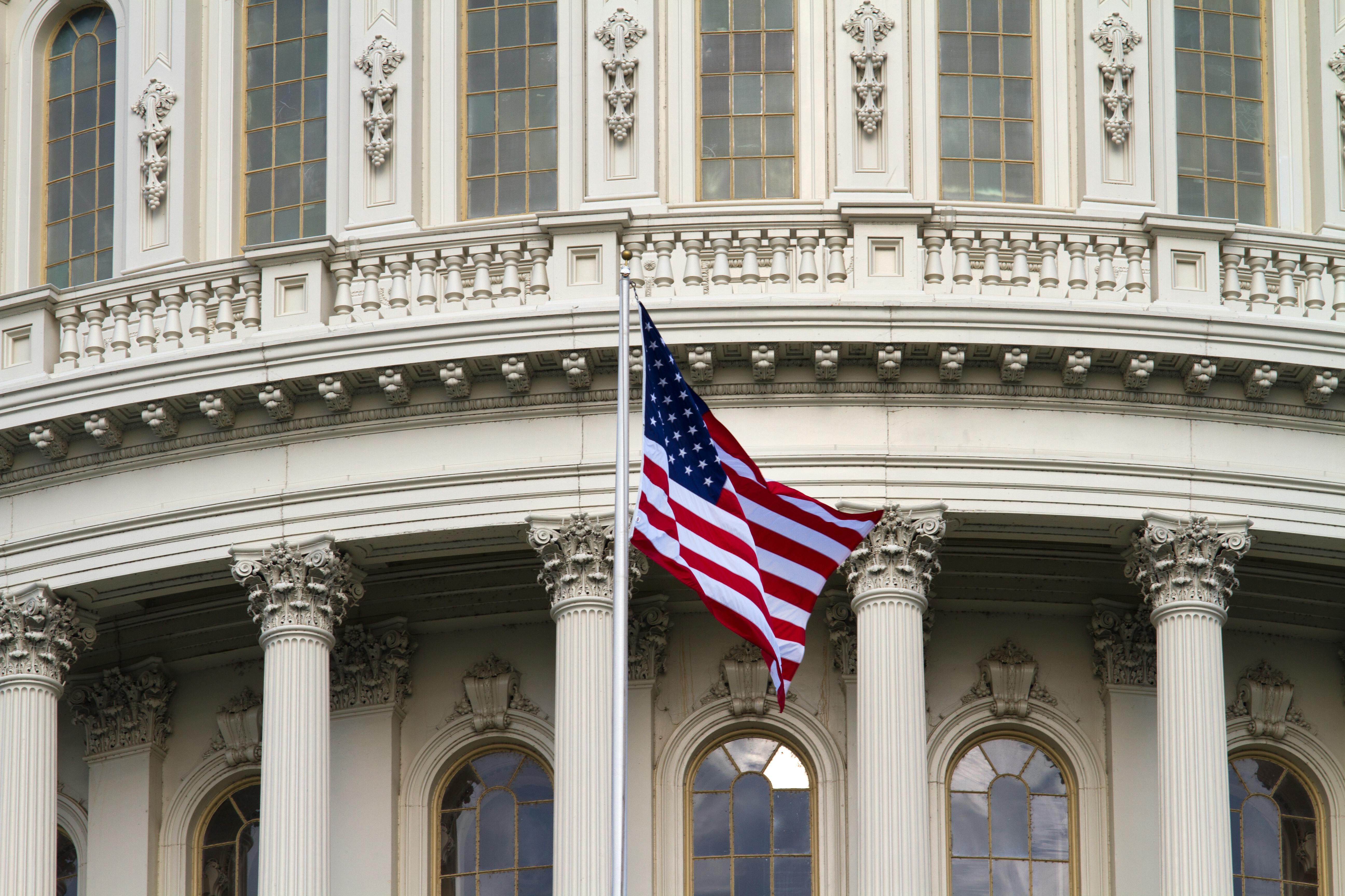 Close-up of the American flag waving outside the United States Capitol in Washington, DC.