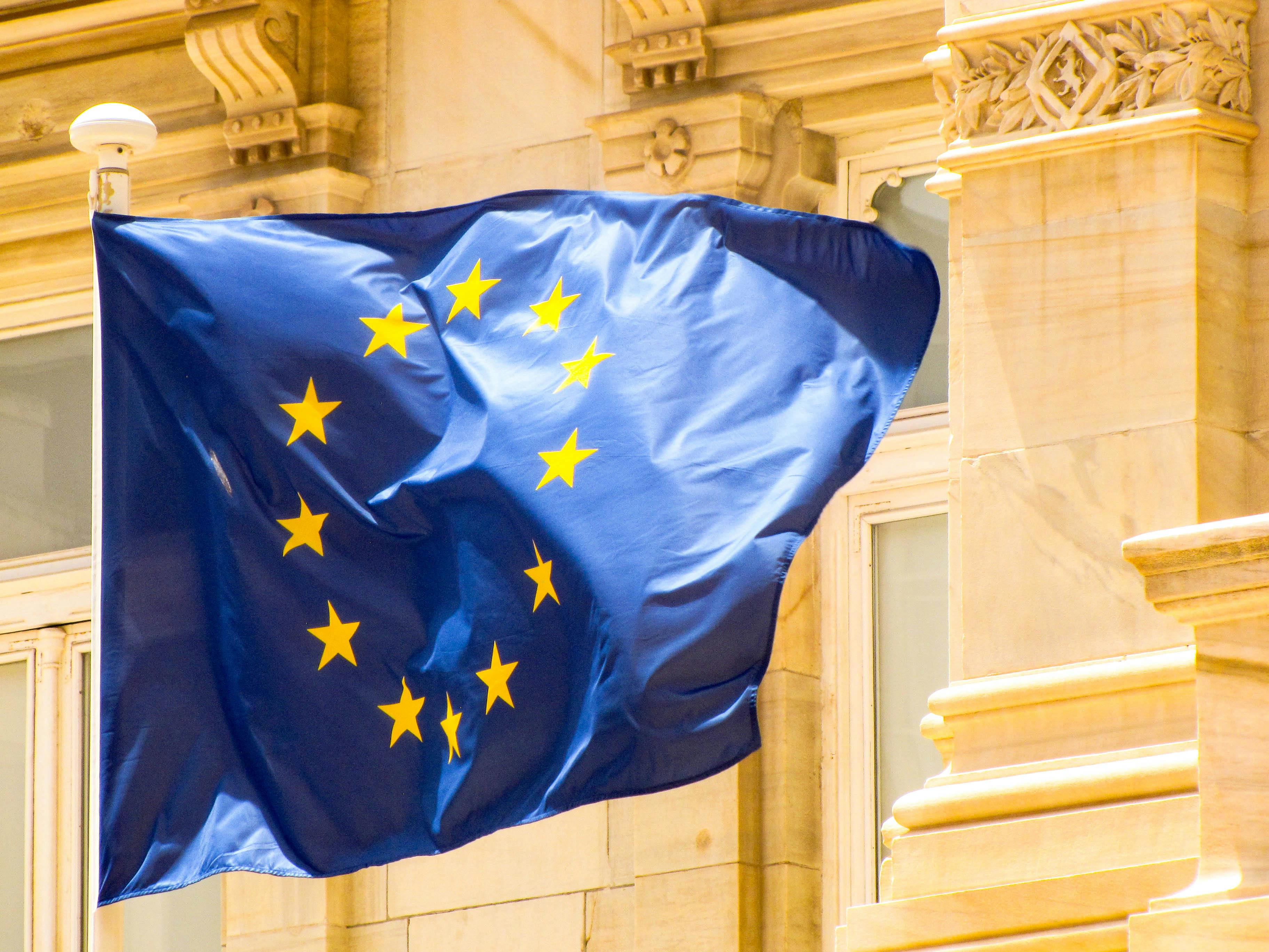 Bright European Union flag waving against historic architecture in Cartagena, Spain.