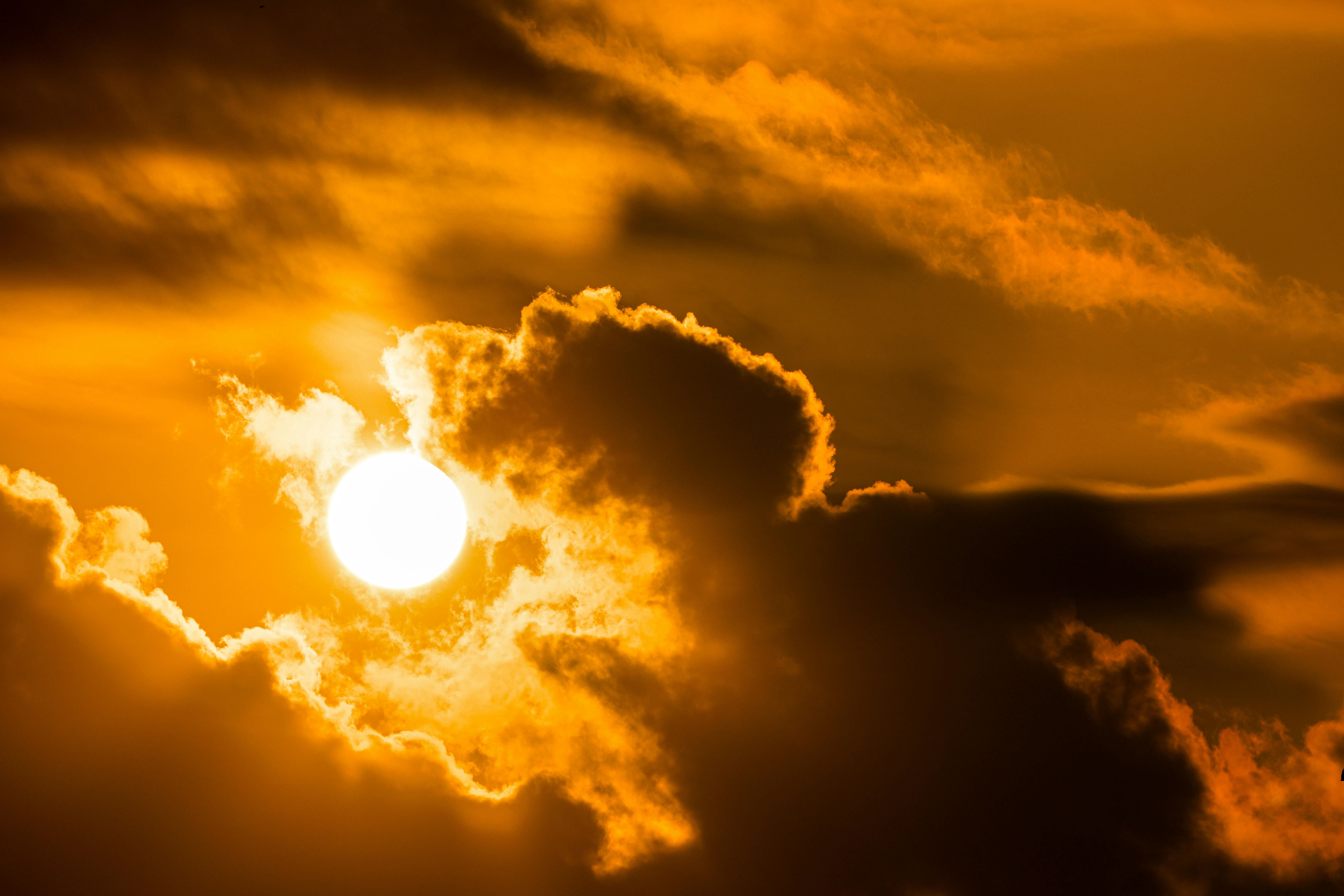 Stunning sunset with vibrant orange clouds and dramatic lighting, perfect for nature themes.